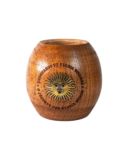Mate Club mate de algarrobo tradicional con aplique de Sol de Mayo en bronce, diseño robusto y cómodo.